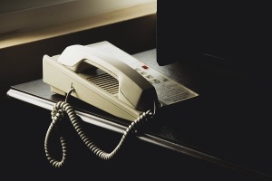 Photo of a desk phone in a dimly lit room. 